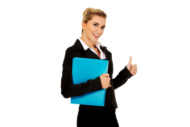 Smiling businesswoman holding a binder - 写真・画像