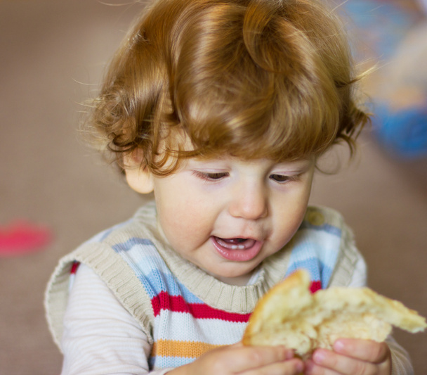 baby with a piece of bread in his hands - 写真・画像