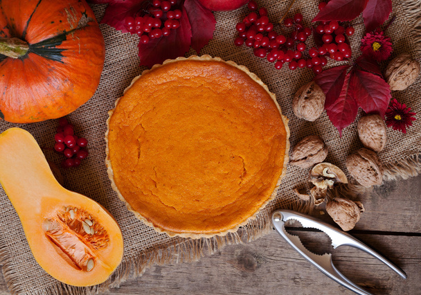 Savoureux traditionnel maison tarte à la citrouille fête d'Halloween doux dessert traiter avec des noix et composition d'automne sur fond de bois vintage
 - Photo, image