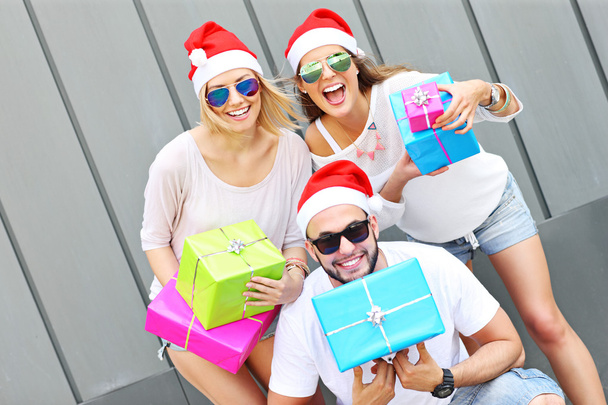 Grupo de amigos en los sombreros de Santa con regalos
 - Foto, imagen
