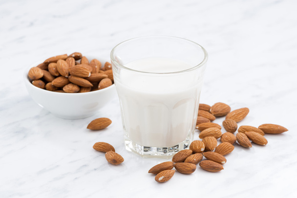 almond milk in a glass on white table - Fotografie, Obrázek