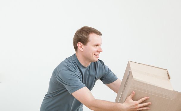 Young man carrying cardboard box - 写真・画像
