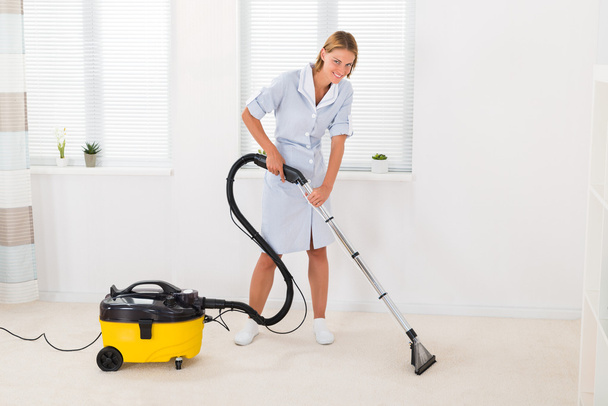 Female Maid Vacuuming Floor - Foto, Imagen