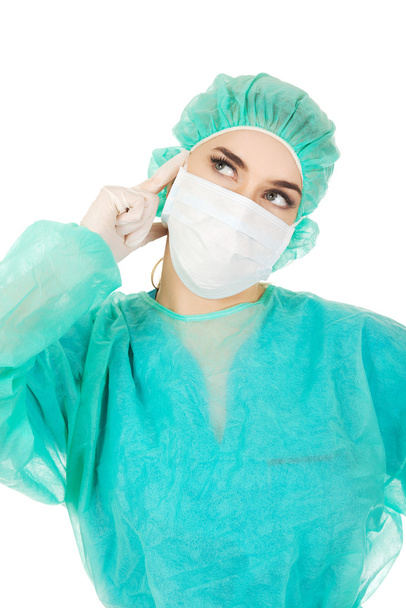 Young woman surgeon doctor thinks about some idea - Fotoğraf, Görsel