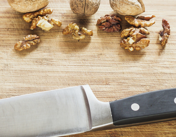 Almendras, nueces y avellanas sobre mesa de madera, surtido de frutos secos, cuchillo
 - Foto, Imagen