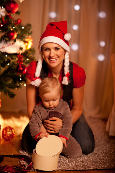Adorable baby near Christmas tree opening Christmas gifts with m - Фото, зображення