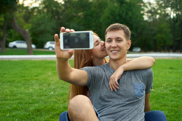 Portrait de couple heureux prenant un selfie dans le parc
 - Photo, image