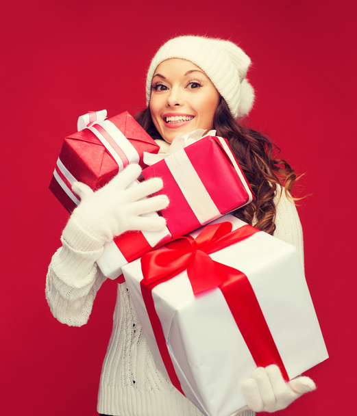 woman in sweater and hat with many gift boxes - Foto, afbeelding
