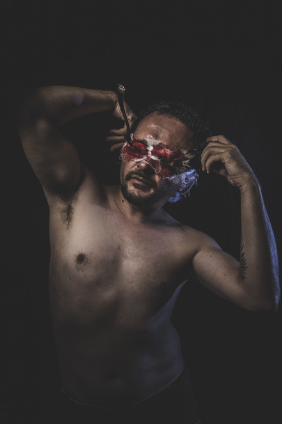Naked man with blindfold soaked in blood - Foto, Imagen