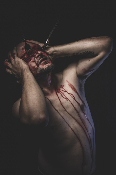 Naked man with blindfold soaked in blood - Foto, afbeelding