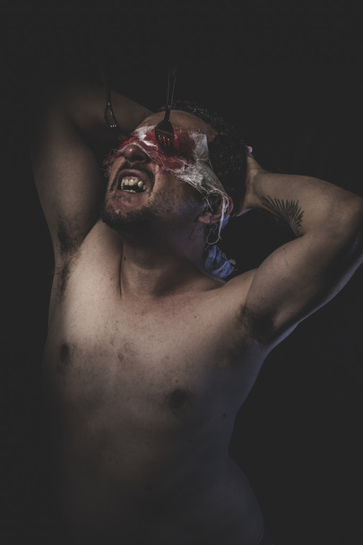 Naked man with blindfold soaked in blood - Photo, image