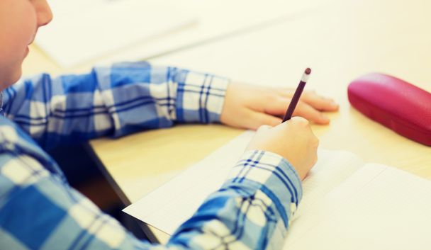 close up of schoolboy writing test at school - 写真・画像