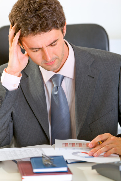 Stressed modern businessman sitting at office desk and working w - Фото, зображення
