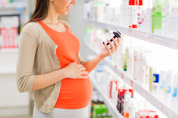 happy pregnant woman with medication at pharmacy - Фото, зображення