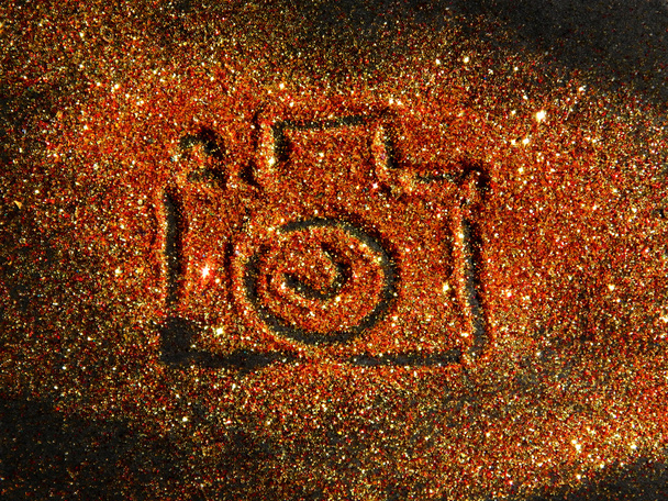 Bulanık fotoğraf makinesi üzerinde altın ve kırmızı parlak siyah arka plan üzerine ışıltı - Fotoğraf, Görsel