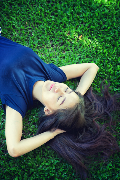 アジア女性緑の芝生でリラックス - 写真・画像