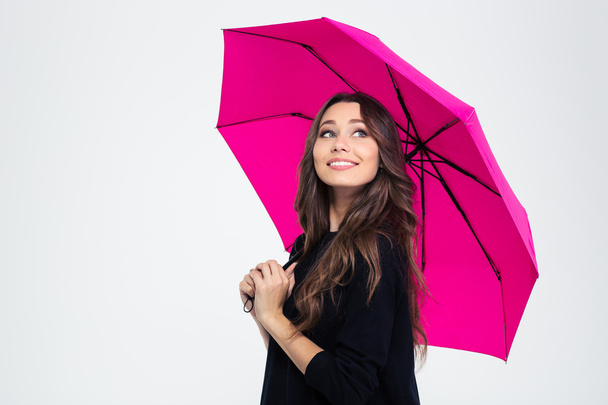 Beautiful woman holding umbrella and looking up - 写真・画像