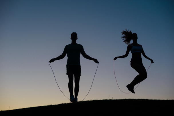 Cara com garota aquecendo em uma corda pulando antes do competiti
 - Foto, Imagem