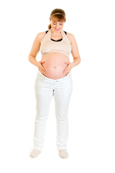 Beautiful pregnant woman holding her belly isolated on white - Photo, image