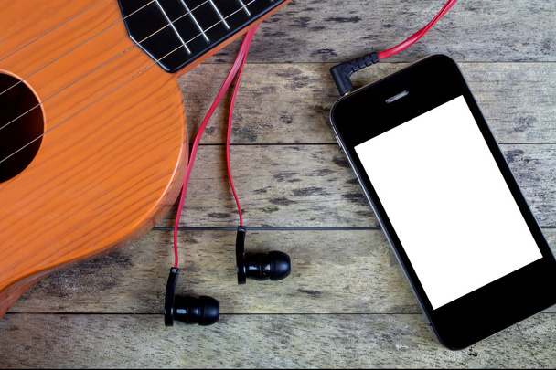 Гітара, навушники та смартфон на дерев'яному столі
 - Фото, зображення