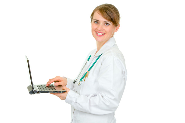 Smiling medical female doctor using laptop - 写真・画像