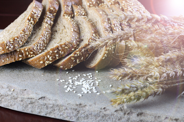 rye bread and ears on the table - Фото, зображення