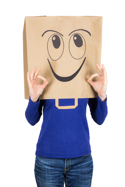 Onnellinen hymyilevä nainen paperipussi päässä
 - Valokuva, kuva