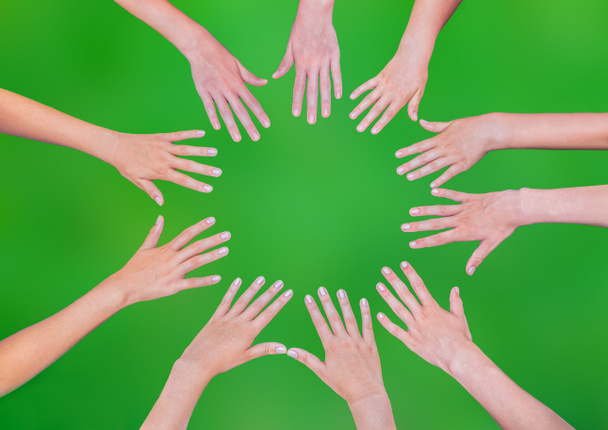 Cinq mains d'enfants joignant en cercle au-dessus du fond vert
 - Photo, image