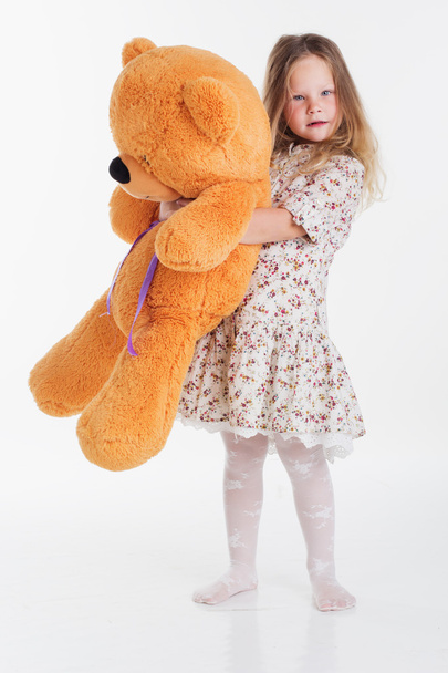 Child girl embraces big teddy bear - Fotografie, Obrázek