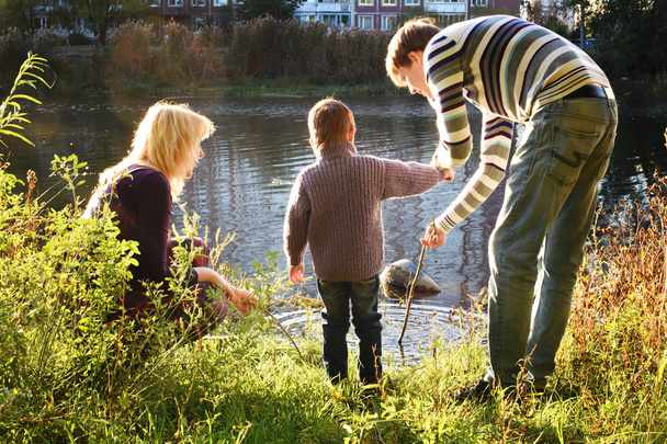 onnellinen perhe leikkii veden äärellä
 - Valokuva, kuva