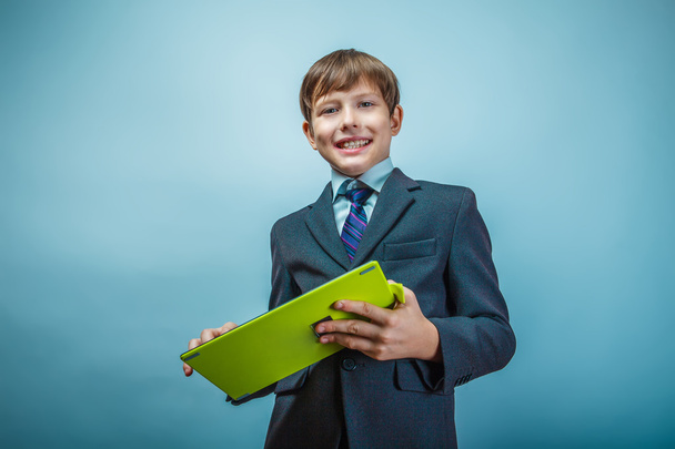 Teen boy businessman European appearance in a business suit hold - Фото, изображение