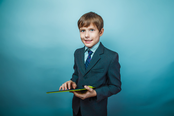 Teen boy businessman European appearance in a business suit hold - Fotoğraf, Görsel