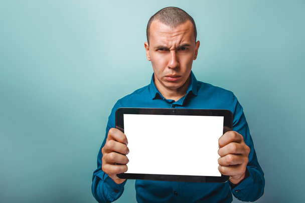 um homem de aparência europeia de trinta anos mostra uma testa tablet
 - Foto, Imagem