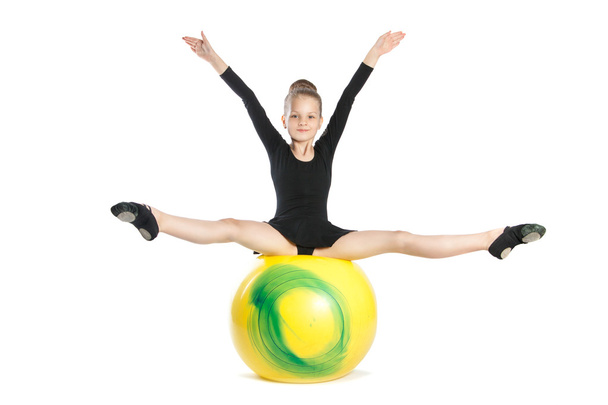 Girl does exercises on a big yellow balloon - Photo, Image