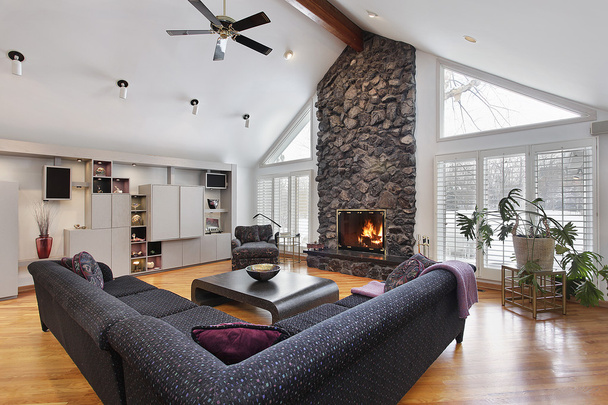 Habitación familiar con chimenea de piedra de dos pisos
 - Foto, Imagen