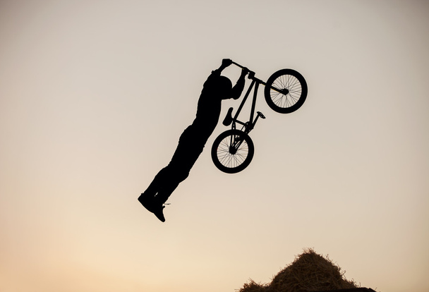 Extremo piloto fazendo um salto de bicicleta
 - Foto, Imagem