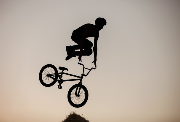 Extremo piloto fazendo um salto de bicicleta
 - Foto, Imagem