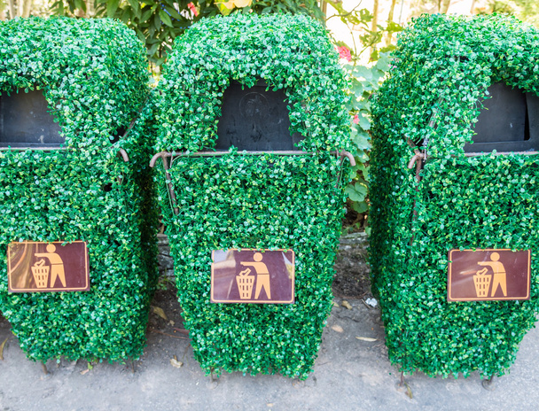 Старый мусорный бак покрыт пластиковыми лозами
 - Фото, изображение