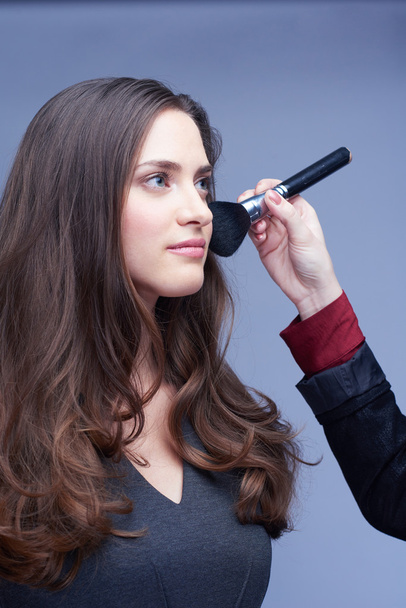 woman portrait in studio during makeup apply - Foto, Imagen