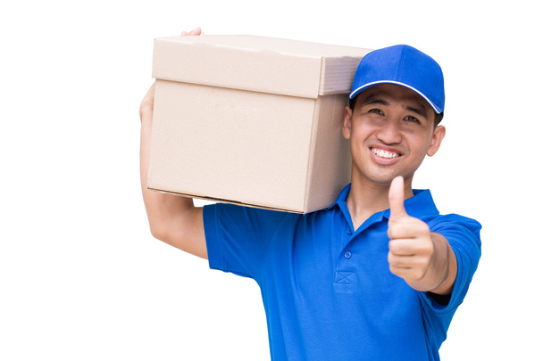 Delivery man carrying a parcel box and giving thumbs up - Фото, изображение
