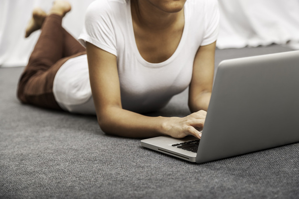 young woman laying while using laptop - Photo, Image