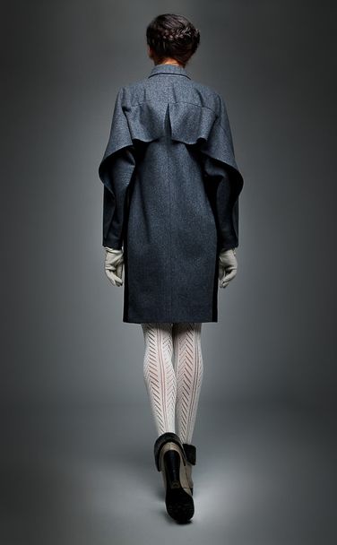 Brunette fashion model in grey coat backwards view - Foto, imagen