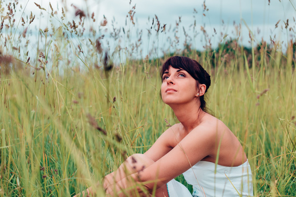 Girl sitting and posing on a meadow. - Zdjęcie, obraz