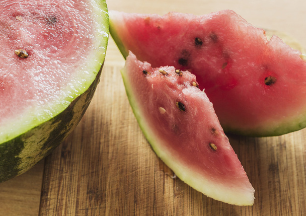 Corte uma fatia de melancia em uma mesa de madeira, rústica, faca
 - Foto, Imagem