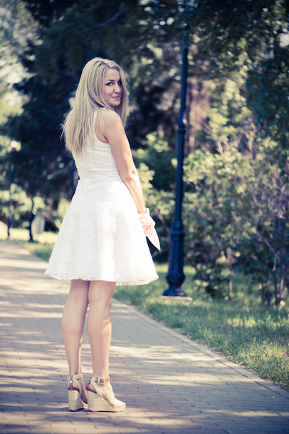 blond woman in a white dress outdoors - Foto, imagen