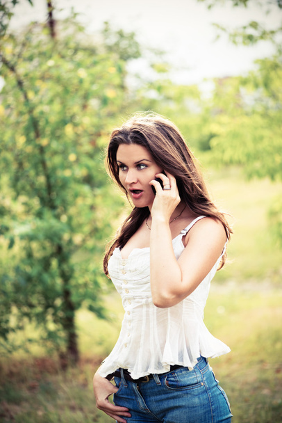 young woman with phone outdoors - Fotó, kép