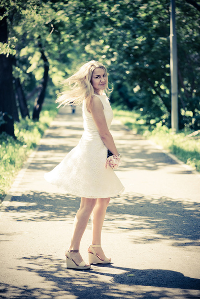 blond woman in a white dress outdoors - Фото, зображення