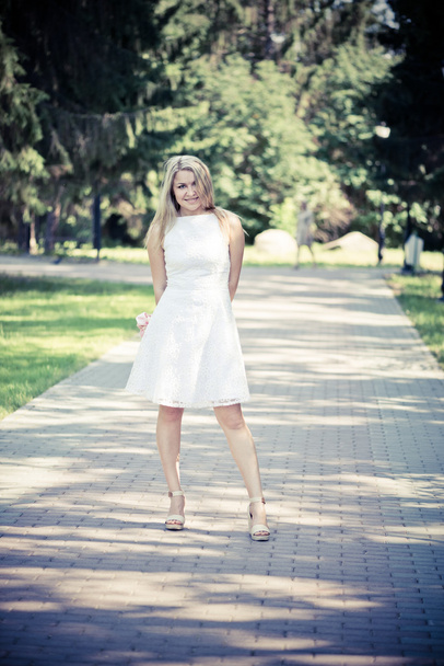 blond woman in a white dress outdoors - Fotografie, Obrázek