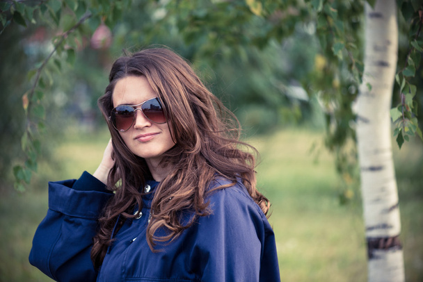 Woman in blue jacket in park - Fotó, kép