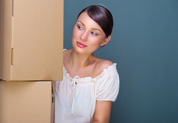 Closeup portrait of a young woman with boxes - 写真・画像
